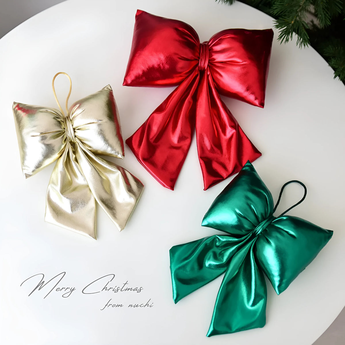 Christmas decorative bowknot with bright leather finish in red colour on a tree branch