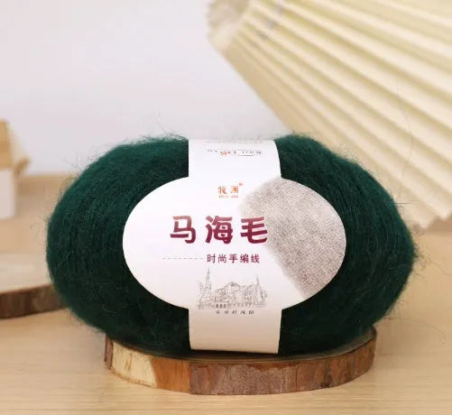 A ball of mohair yarn in a selected colour next to a hand-woven scarf example, showcasing the DIY kit.