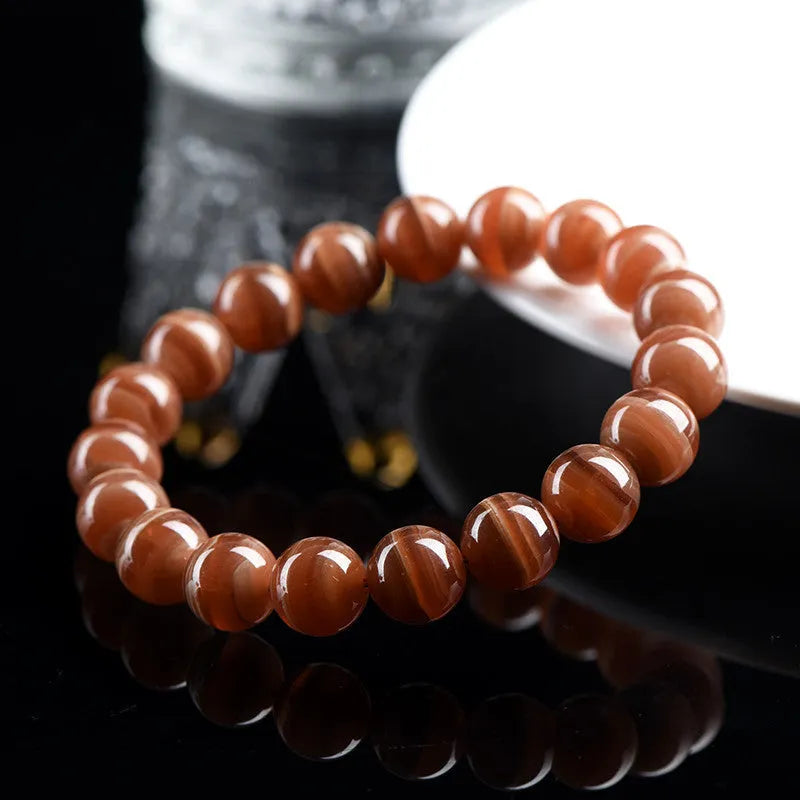 Natural Old Mine Rhodochrosite round bead bracelet with Ruyi charm, shown in 6mm and 8mm size options.