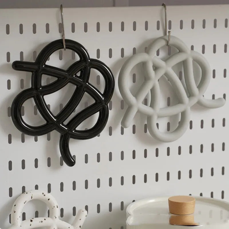 Ceramic heat proof mat in splash ink colour with bend and hook on wooden table