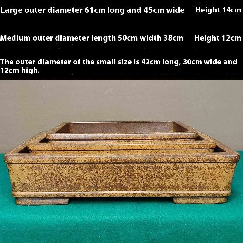 Straight-sided shallow rectangular Yixing flowerpot made from unglazed purple clay on a wooden surface.