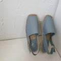 Women's beige retro-style flat sandals with an animal pattern on the canvas upper.
