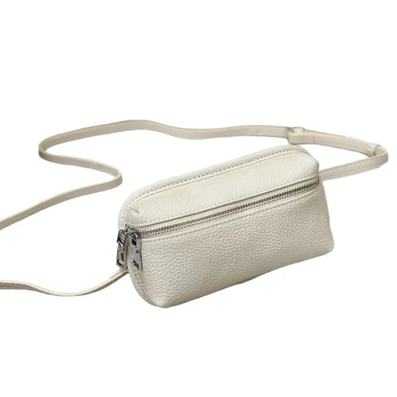 Mini crossbody bag in top grain leather with polyester lining, retractable handle, welt pocket, and solid colour patchwork design.
