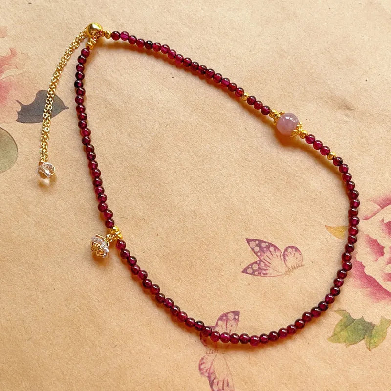 Close-up of a women's double ring bracelet made with natural garnet stones in H311 colour.