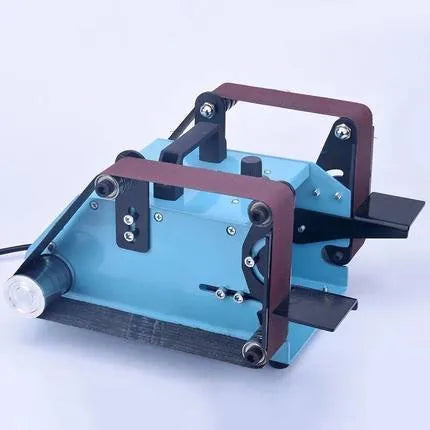 Blue desktop belt sander with variable speed control for sharpening knives and tools on a workbench.