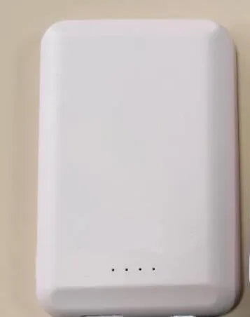 A black magnetic wireless power bank with a 5000mAh capacity, shown attached to a mobile phone.