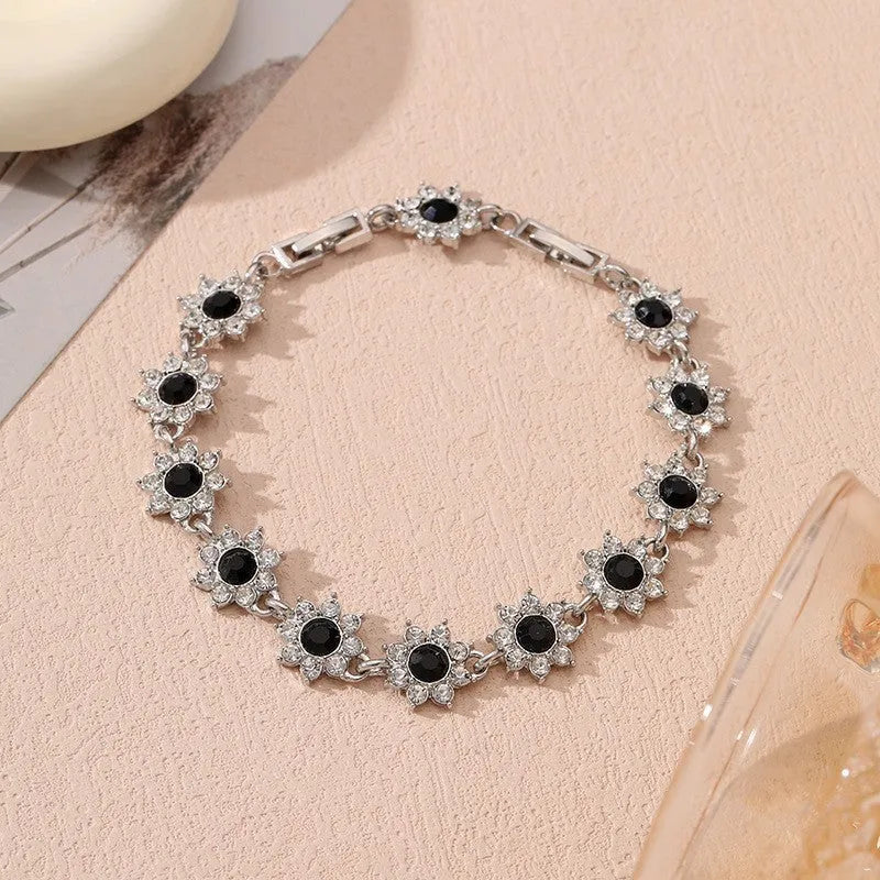 Coloured gemstone bracelet with flower-shaped design in gold and silver colour variations