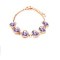 Heart shaped alloy bracelet with crystal inlay, shown in a choice of seven colours including sapphire blue and light purple.