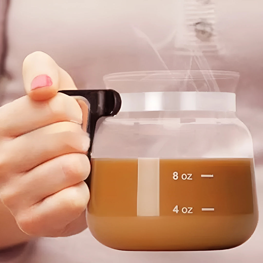 Transparent borosilicate glass coffee maker with a black silicone cover on a kitchen counter.