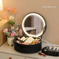 Round black smart LED makeup bag with lighted mirror open, showing internal partitions.