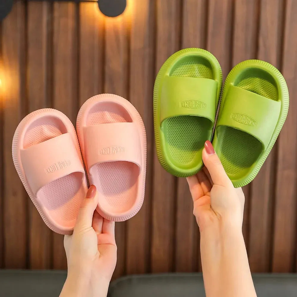 Colourful children's EVA slippers with textured non-slip sole, shown in blue, green, orange, pink, and yellow.