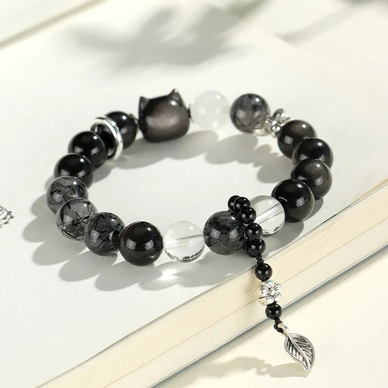 Silverstone crystal beaded bracelet with fox, cat head, and planet charms in white, pink, navy blue, and black.