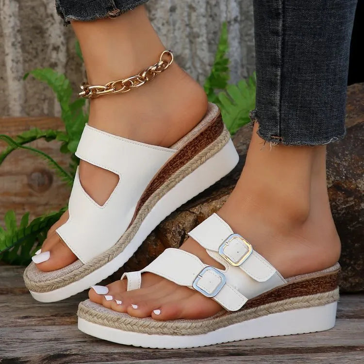 White patent leather wedge sandals with woven upper and finger fit design on a rubber sole.