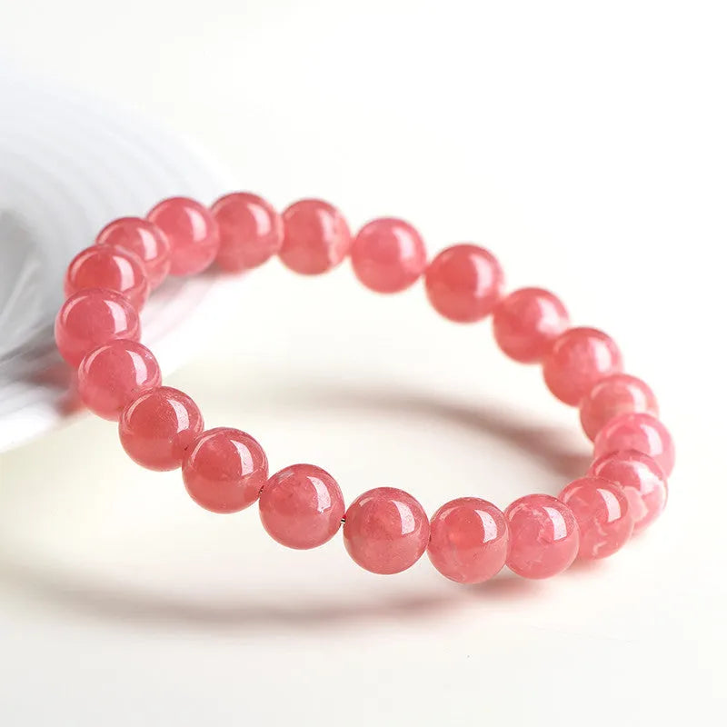 Women's crystal bracelet with a longevity lock clasp and geometric beads in rhodochrosite colours.