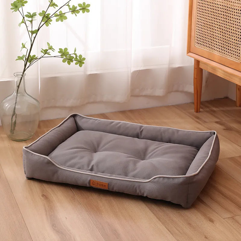 Grey waterproof dog sofa bed with a soft cushion, shown next to a sleeping golden retriever.