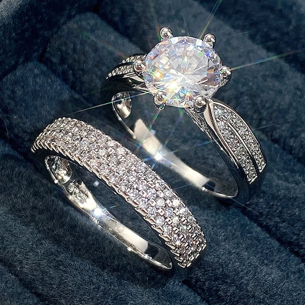 A white gold-coloured geometric bracelet ring with an integrated round element on a model's finger.