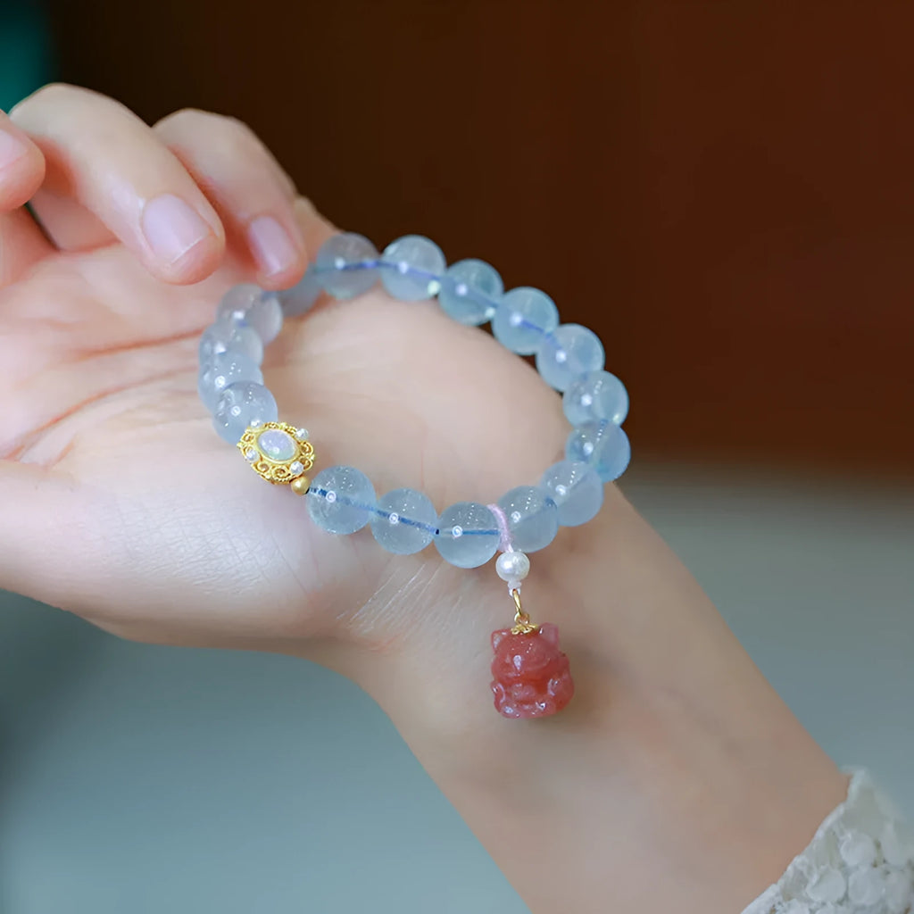DIY kit components for an aquamarine fox Fengjiu bracelet with pearl and pink crystal beads.