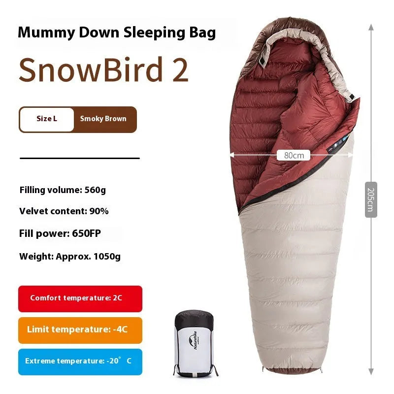 Goose down mummy sleeping bag in a stuff sack, part of the snowbird range for camping.