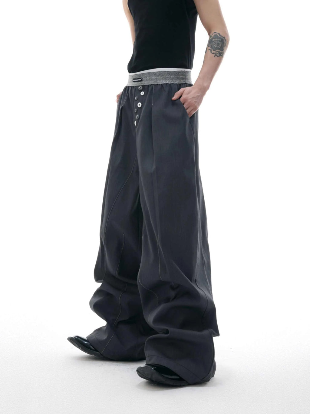 A pair of high-waisted straight-leg casual trousers in grey, showing the button-fly detail.