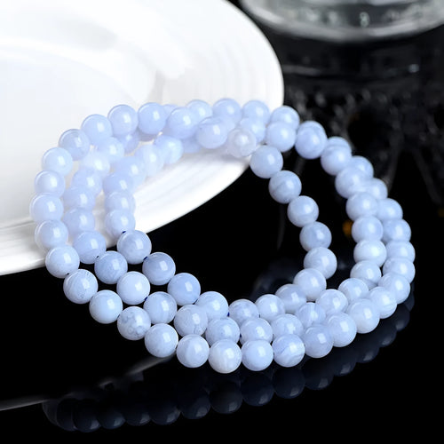 Blue agate bracelet with multi-circle pattern and scattered striped beads on a wrist.