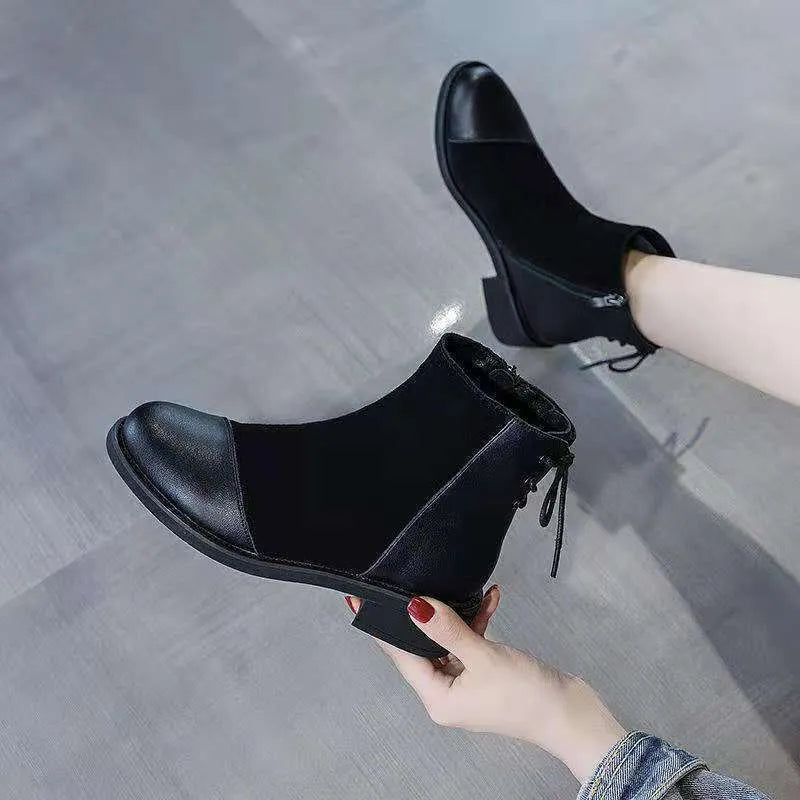 Black women's knee-high martin boots with side zipper and round toe on a rubber sole.