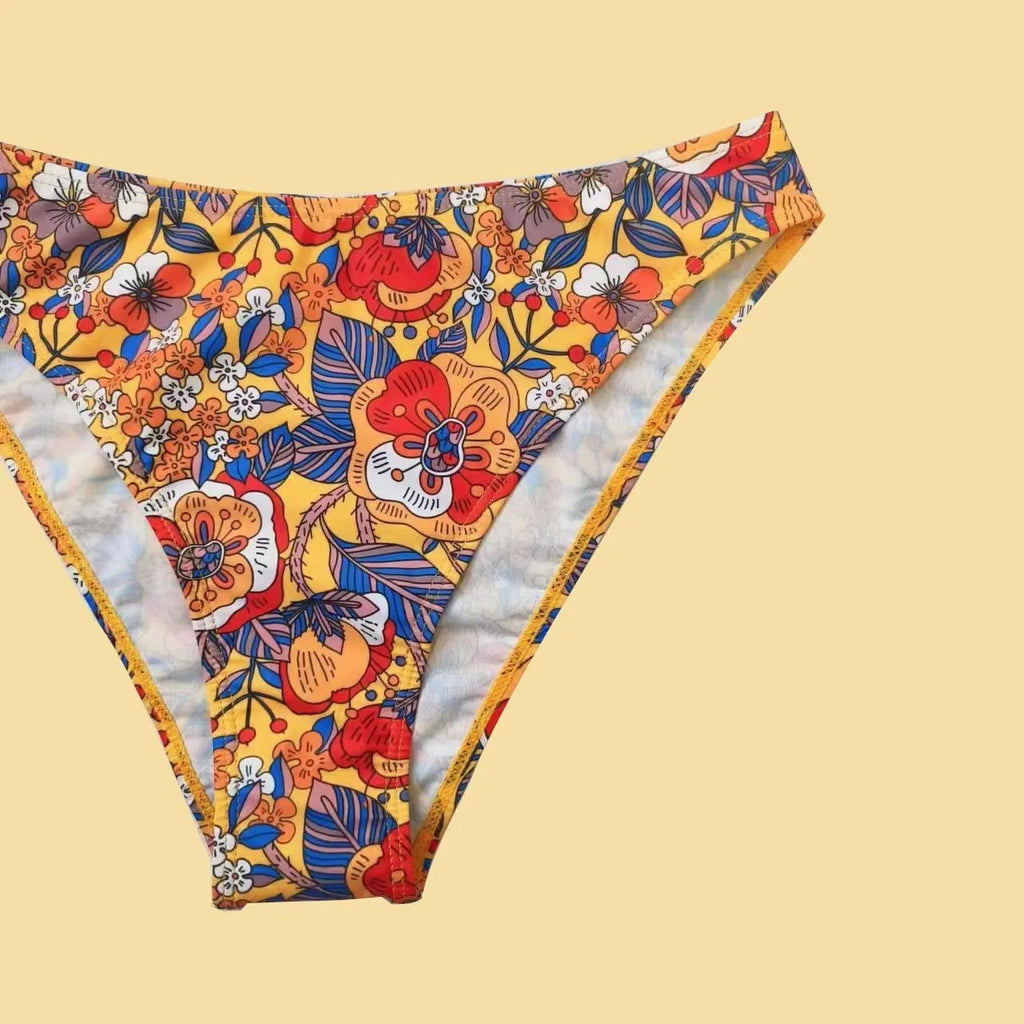 Plus size women's floral print strap bikini swimsuit set in brief style on a mannequin