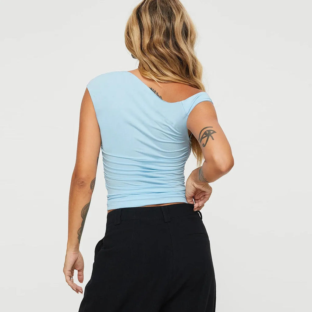 Sleeveless pleated top with oblique collar and irregular hem in light blue or white