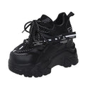 Women's white low-top platform sports shoes with a mesh upper and cross-strap detail.