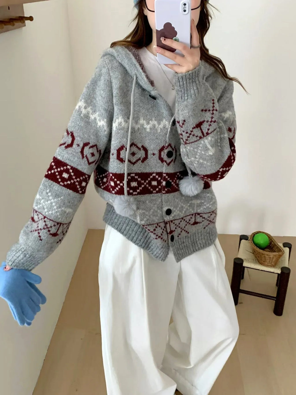 Plus size woman wearing a loose, geometric patterned grey acrylic sweater coat.