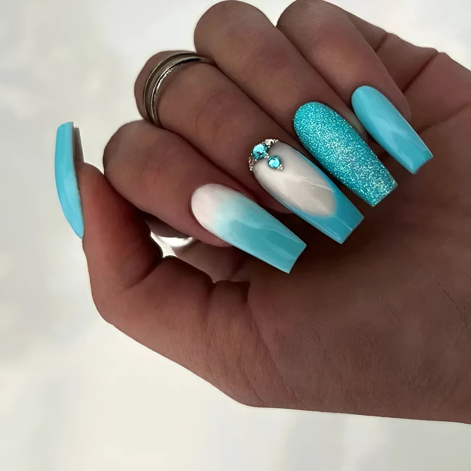 Long ballet shaped artificial nail patches with smart blue diamond pattern on solid blue background