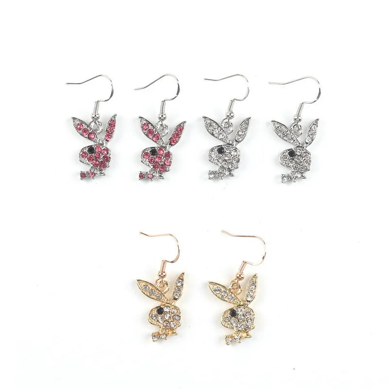 Close-up of a pair of sparkling rabbit silhouette stud earrings with cubic zirconia stones on a silver background.