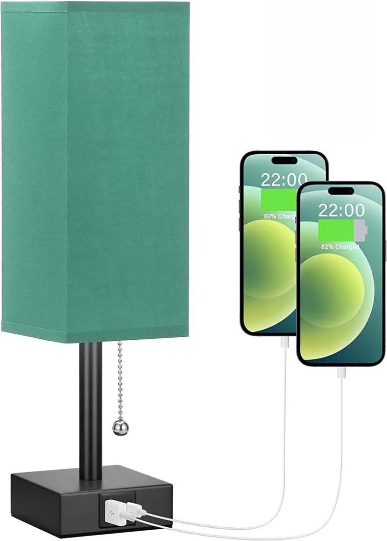Small bedside table lamp with fabric shade and USB charging ports on a nightstand with pull chain control