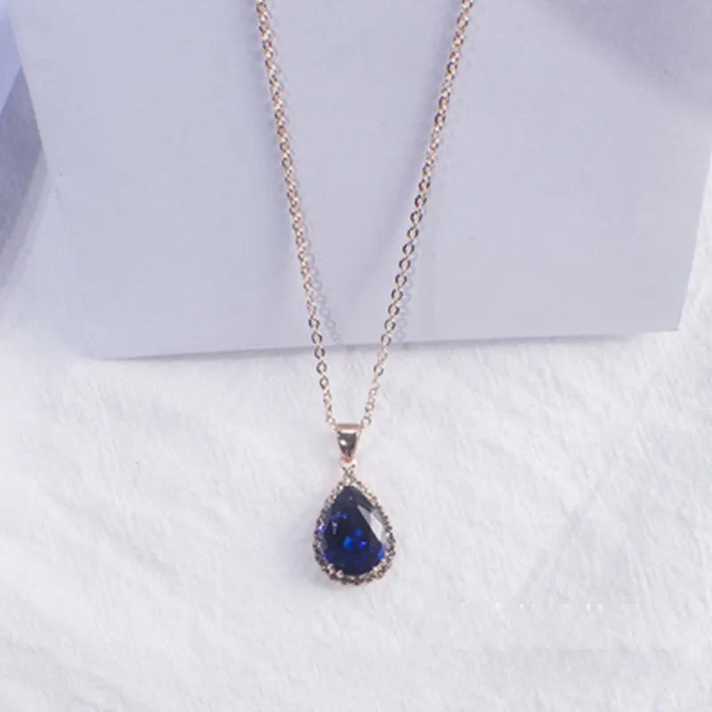 Rose gold water drop shaped necklace with geometric design and rhinestone accents in pink colour