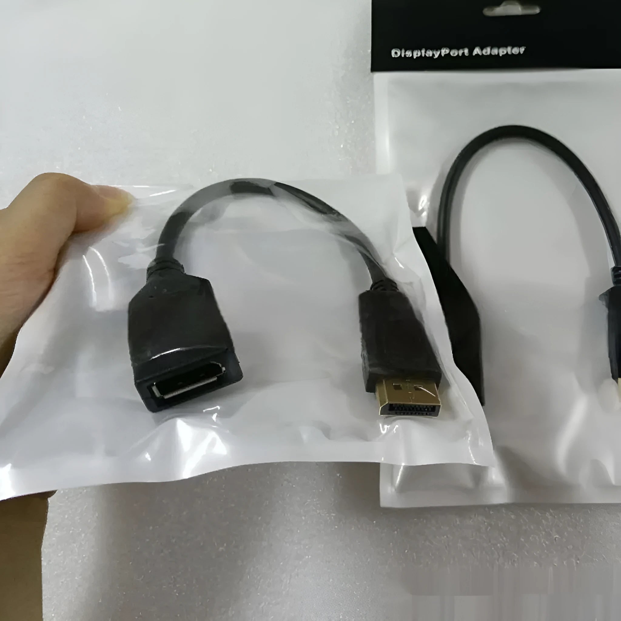 Black DisplayPort male to female extension cable approximately 10cm long with rotating connector