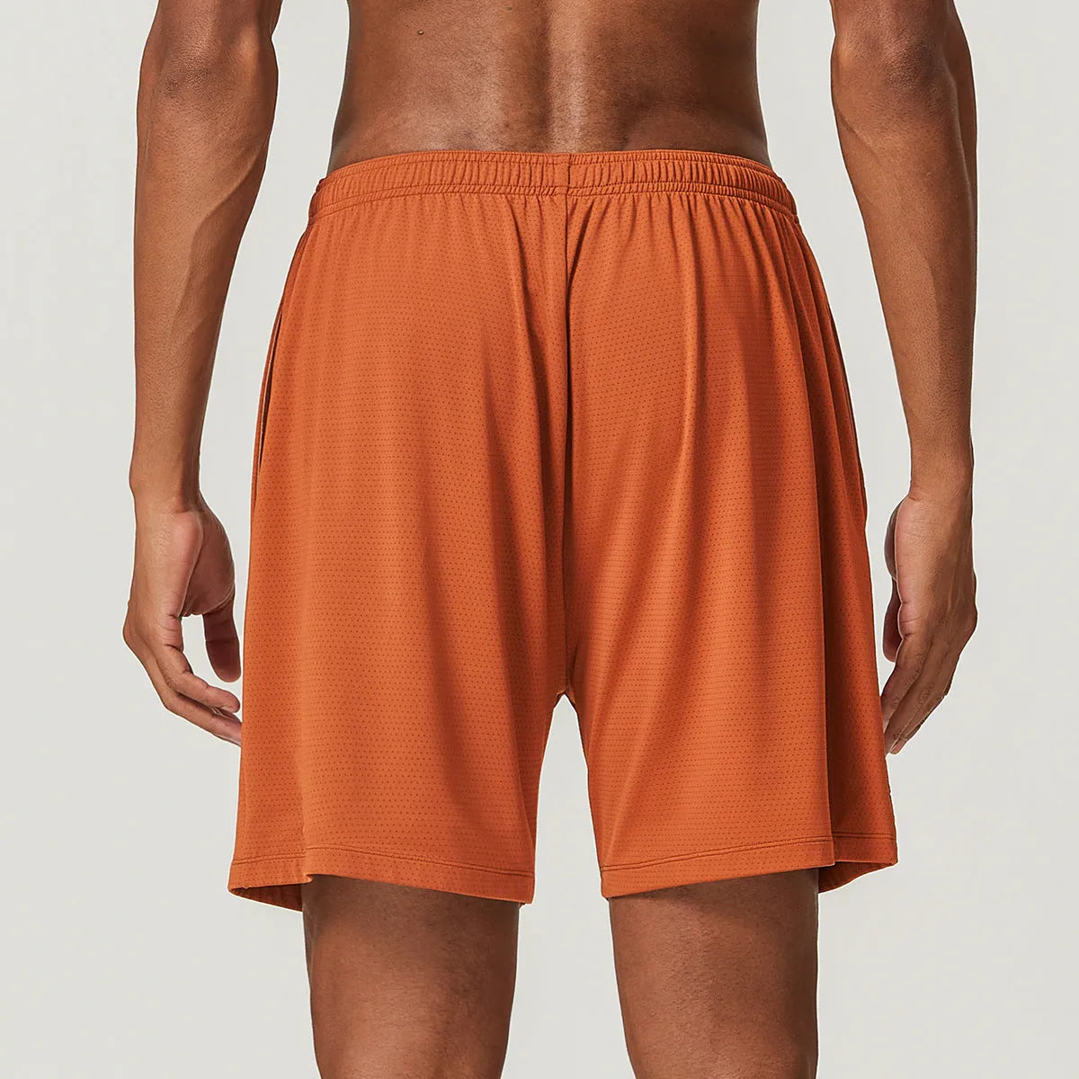 Man wearing sky green double-layer men's running shorts with a mid-waist fit.