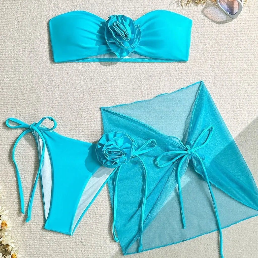 Women's pink tube top swimsuit with large 3D flower and matching skirt set on beach