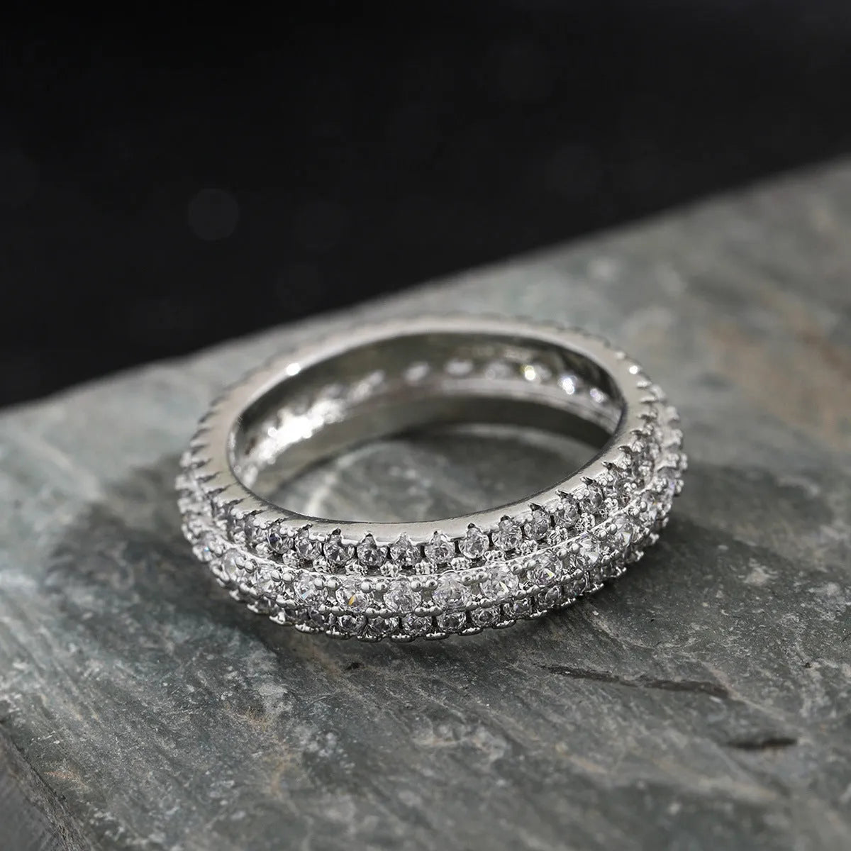 Geometric triangle ring with a zircon stone in a copper band, shown in white gold finish.
