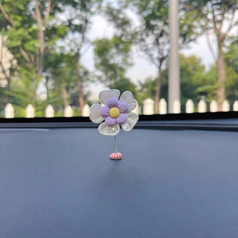 Small colourful plastic swing car decoration for dashboard or mirror.