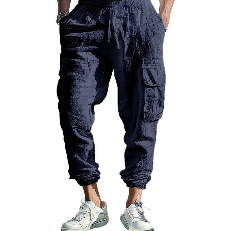 Men's loose-fit linen trousers with ankle ties and a drawstring waist in a solid colour.