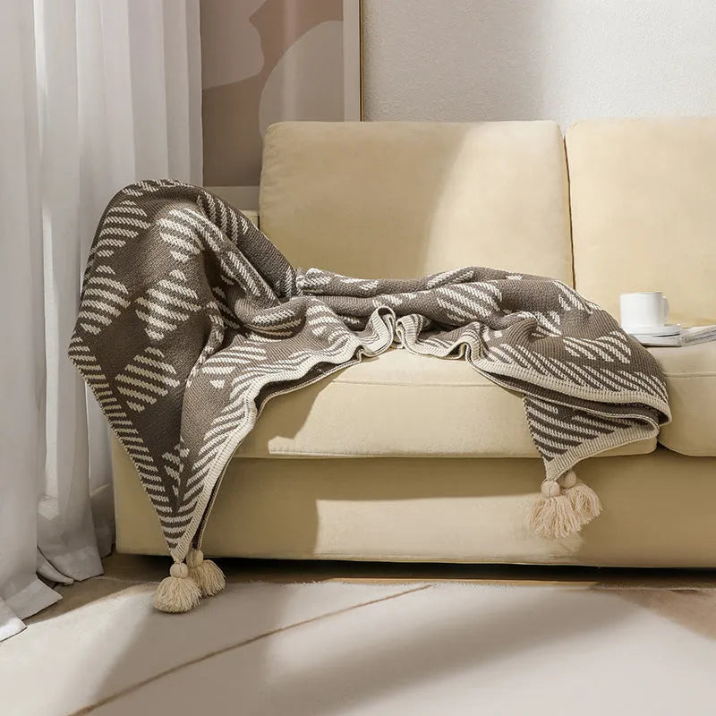 Bohemian style acrylic sofa cover blanket with tassel trim in a geometric pattern colour option.