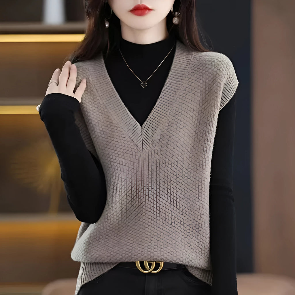 Creamy-white V-neck sleeveless knitted vest with a raised 3D pattern, laid flat.