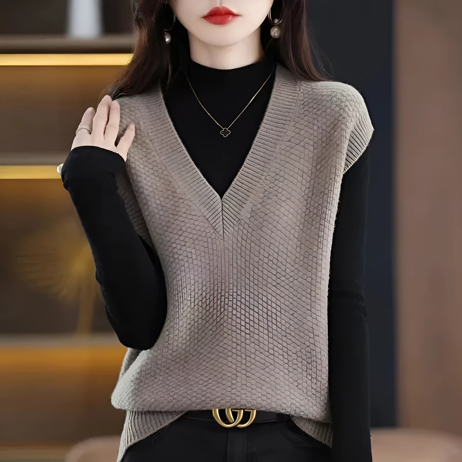 Creamy-white V-neck sleeveless knitted vest with a raised 3D pattern, laid flat.