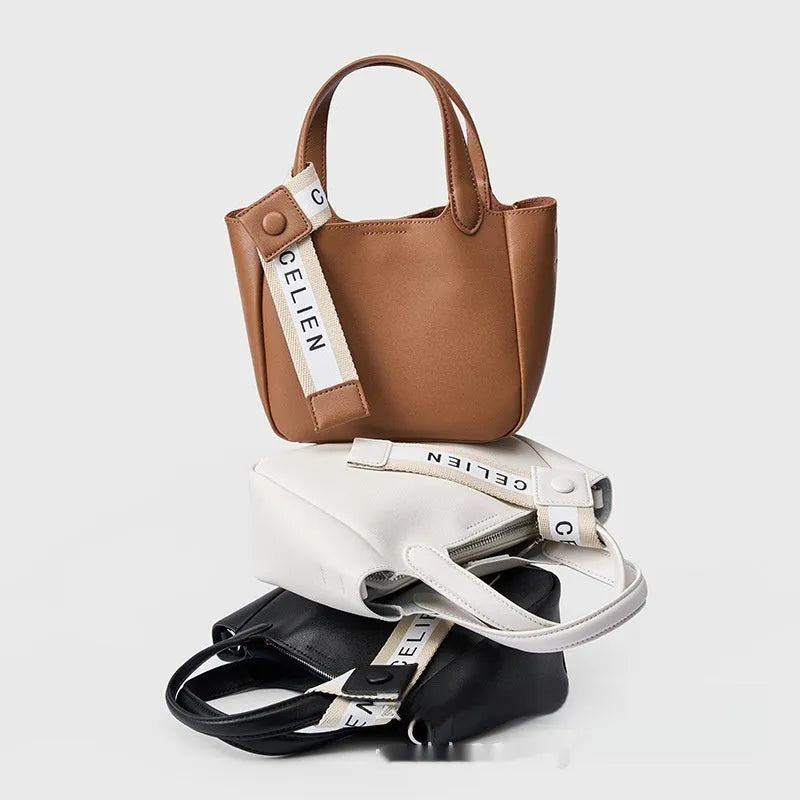 Genuine cattlehide leather retro crossbody bucket bag in black showing external slit pocket and sewing thread detail.