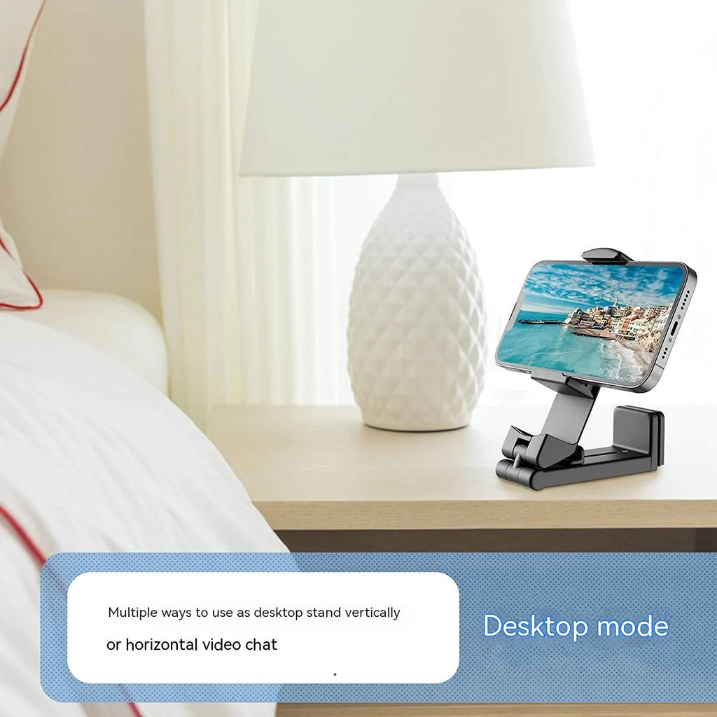 Black foldable and rotating universal mobile phone holder on a table.