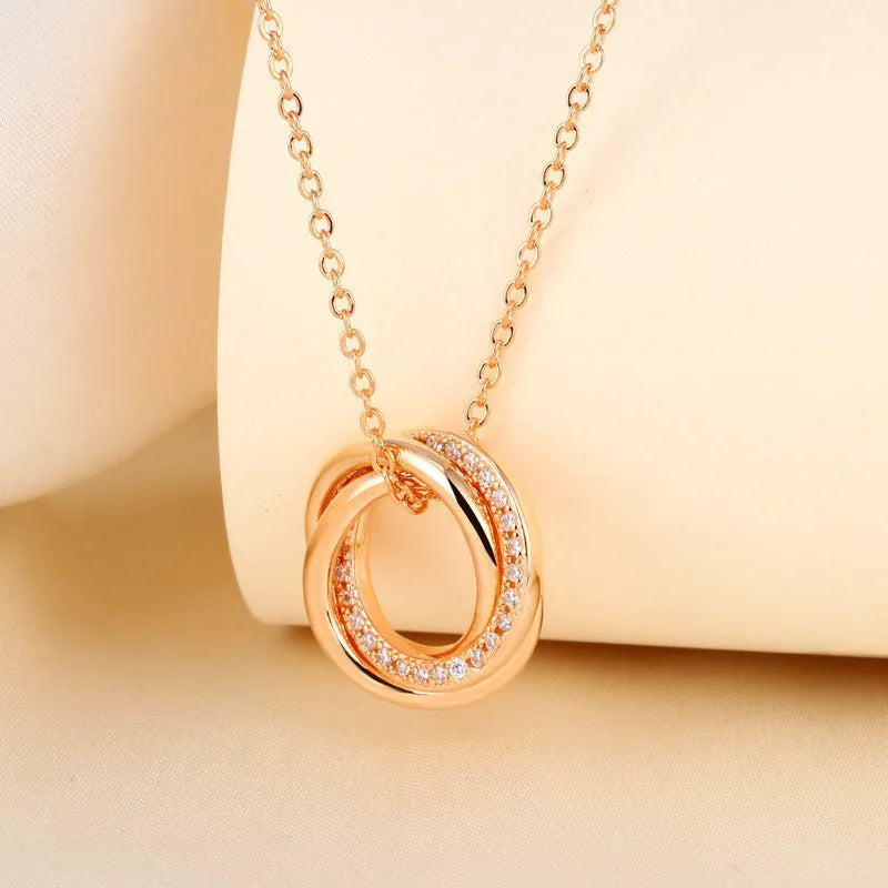 Geometric copper necklace with micro-inlaid interlocking three rings in champagne gold on woman
