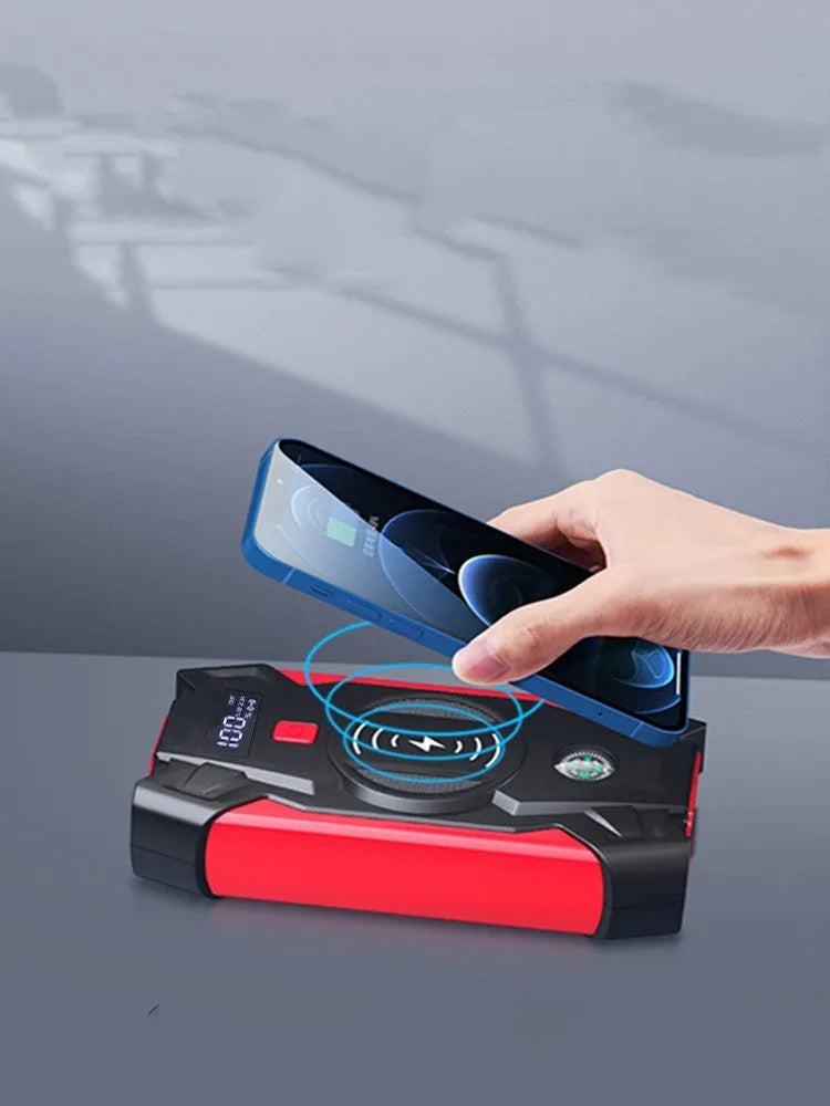 Red 12V car battery jump starter power pack with battery clips on a black background.