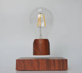 Magnetic levitation floating light bulb with imitation wood base on a table.