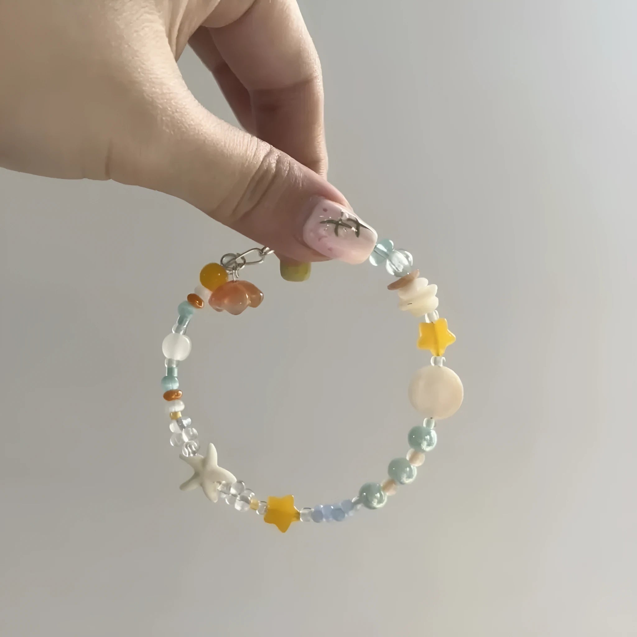 Women's orange summer bracelet with a diamond-shaped alloy centrepiece on a mixed-material band.