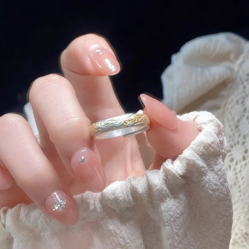 Geometric open-mouth silver and gold ring with a Xiangyun cloud pattern on a white copper band.