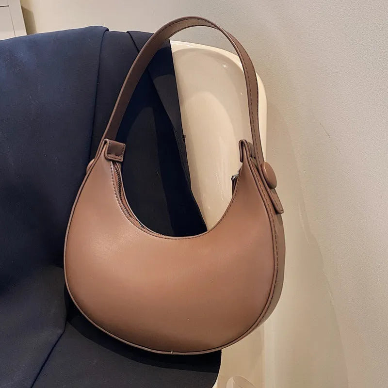 Retro dumpling-shaped women's shoulder bag in PU leather, shown in cream yellow colour.